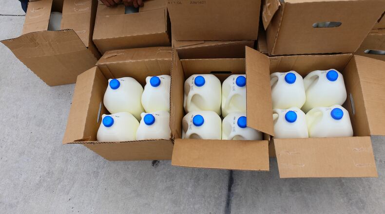 Boxes filled with gallons of milk are opened for distribution in this 2021 file photo from Brownsville, Texas.  (Denise Cathey/The Brownsville Herald via AP)