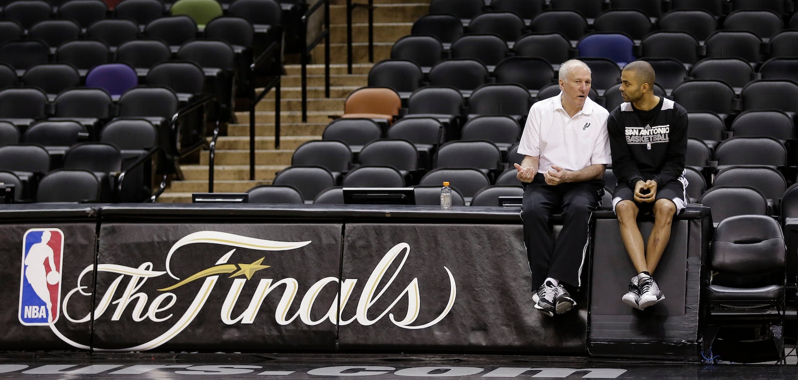 FILE - San Antonio Spurs head coach Gregg Popovich, left, and guard Tony Parker, right, of France, talks during practice, Wednesday, June 12, 2013, in San Antonio, ahead of Game 4 of the NBA Finals against the Miami Heat. (AP Photo/Eric Gay, File)