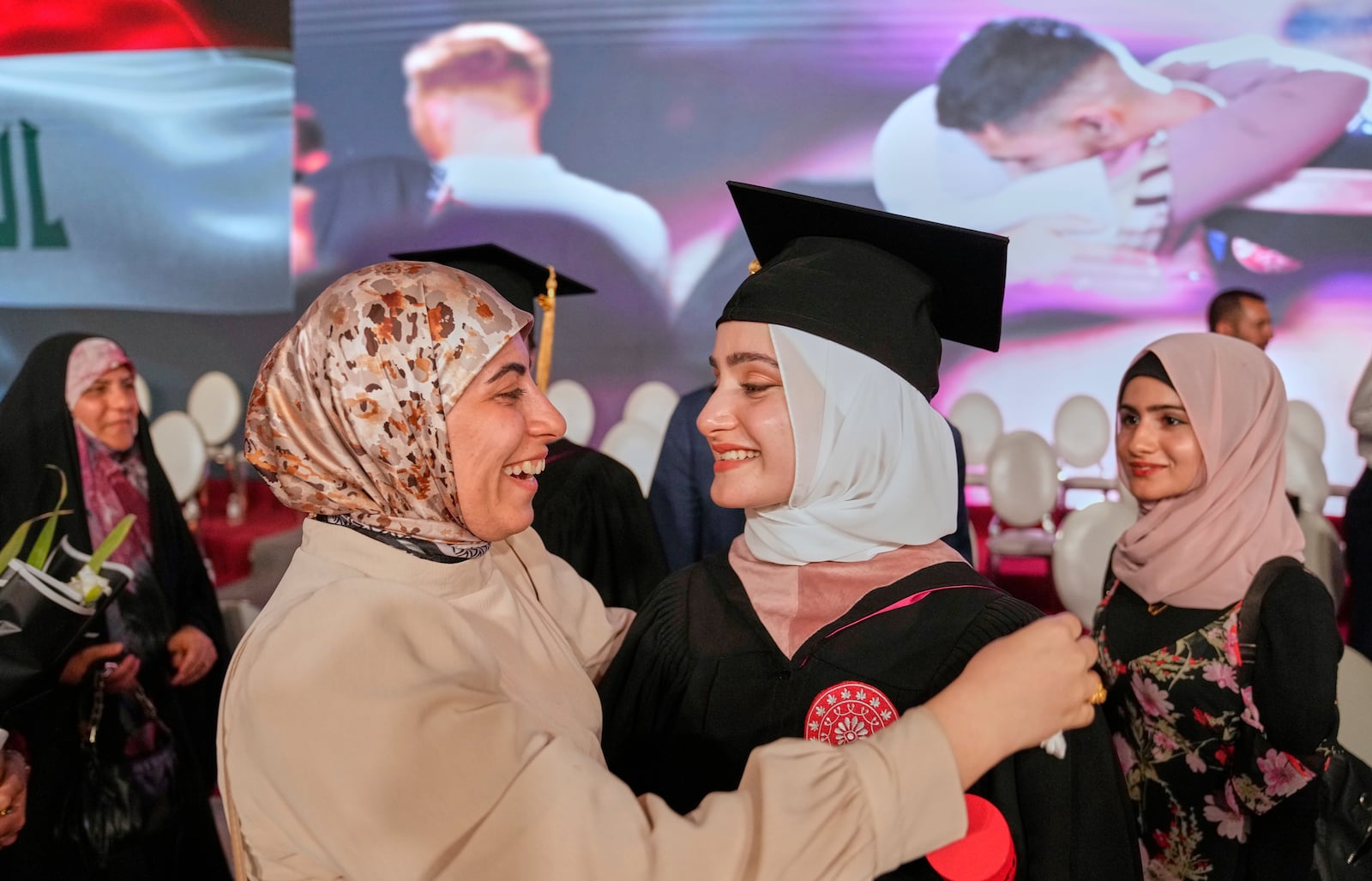 An Iraqi mother celebrates with her daughter during the first graduation for The American University of Iraq - Baghdad students in Baghdad, Iraq, Saturday, May 24, 2025. (AP Photo/Hadi Mizban)