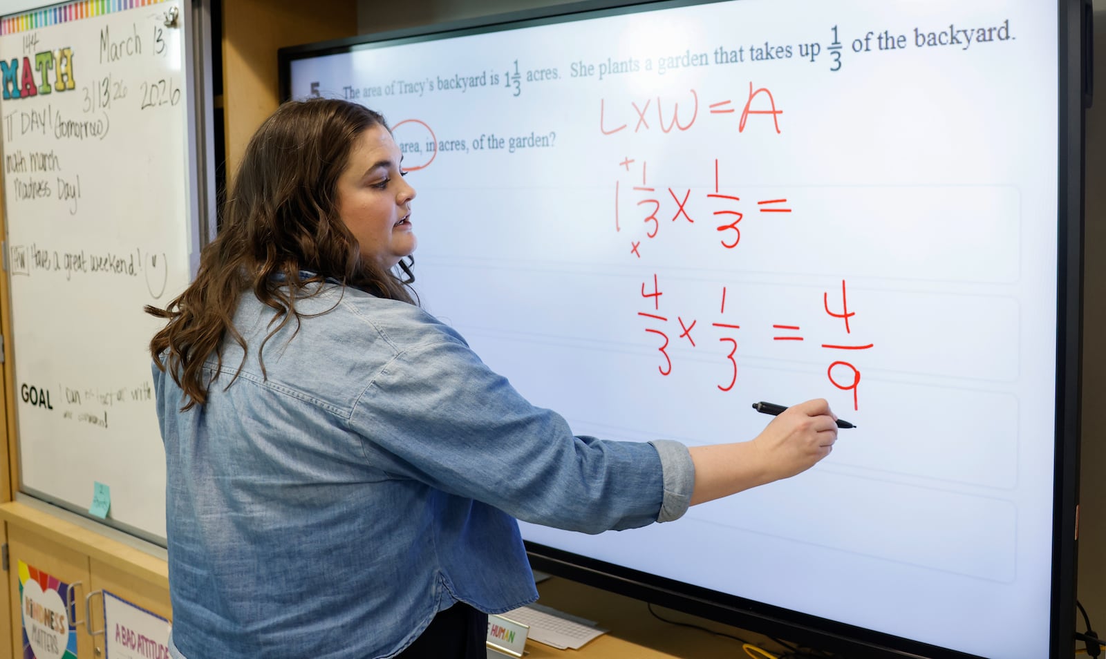 Fifth grade math teacher Allison Cody solves an equation for her students at Greenon Elementary School on Friday, March 13, 2026, in Enon. She's one of four teachers who will receive an Excellence in Teaching Award on March 23. JOSEPH COOKE/STAFF