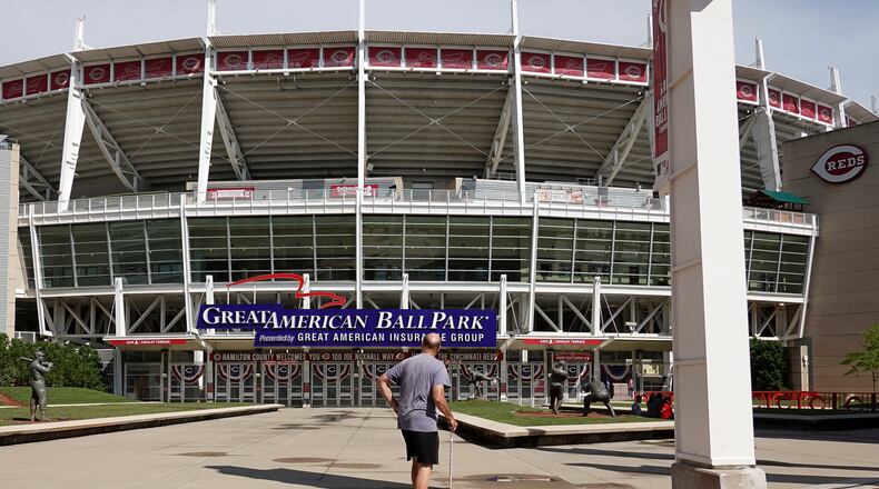 Steven Taylor, of Cincinnati, walks past The Great American Ball Park prior to an exhibition baseball game between the Cincinnati Reds and the Detroit Tigers in Cincinnati, Wednesday, July 22, 2020. (AP Photo/Bryan Woolston)