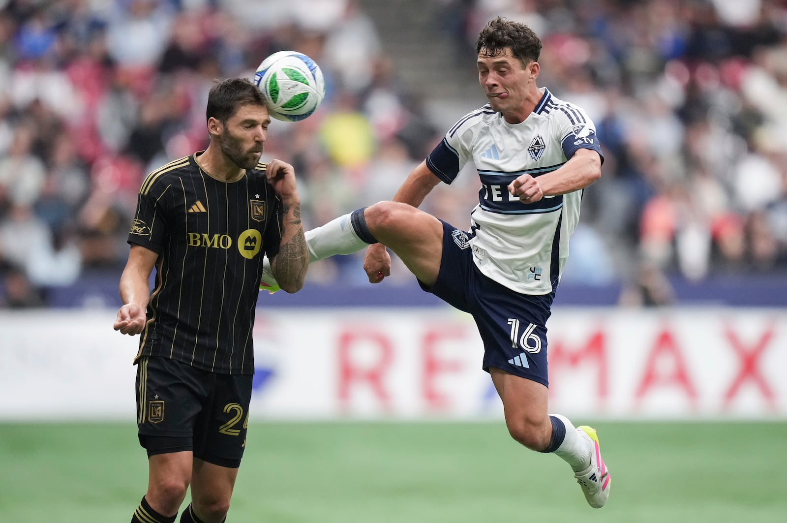 Vancouver Whitecaps' Sebastian Berhalter, right, and Los Angeles FC's Ryan Hollingshead, left, vie for the ball during the second half of an MLS soccer match in Vancouver, British Columbia, Sunday, May 11, 2025. (Darryl Dyck/The Canadian Press via AP)