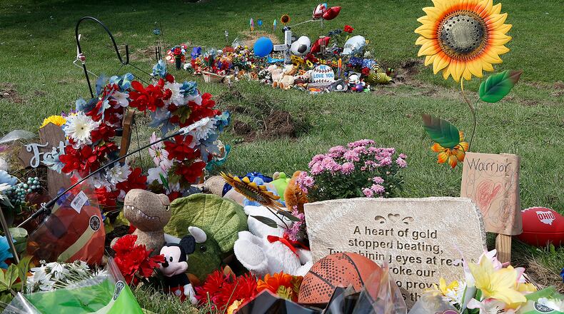 Memorial items and toys are stacked along Troy Road Thursday, August 24, 2023 at the site of Tuesday fatal bus crash. The memorial, which continued to grow, has been removed at the request of Aiden Clark's family. The 11-year-old died in the crash, and two dozen other students were injured. BILL LACKEY/STAFF