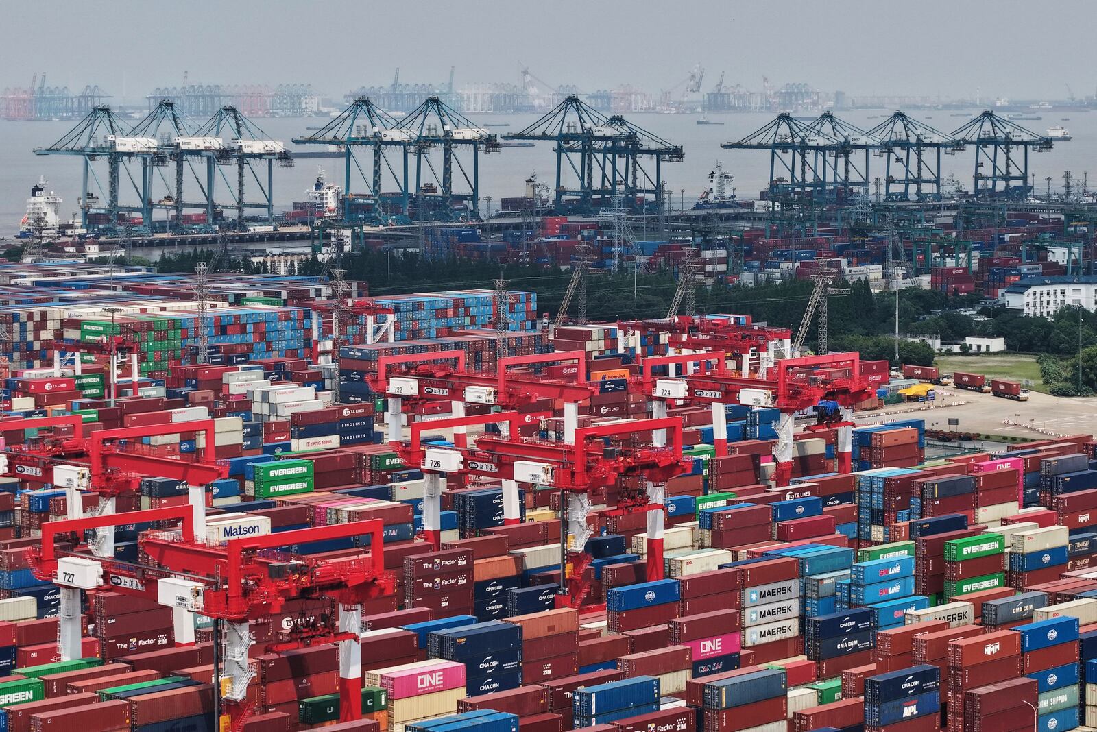 Trucks loaded with container move through a container terminal port in Shanghai, China Monday, June 9, 2025. (Chinatopix Via AP)
