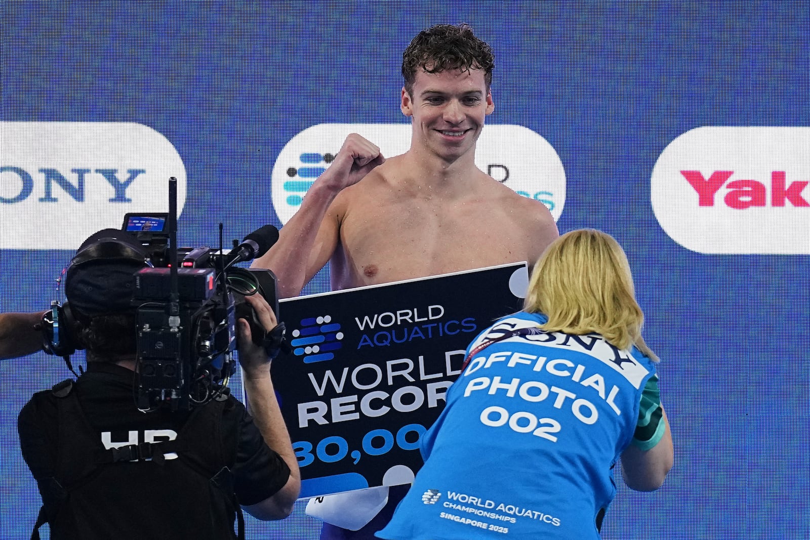 Leon Marchand of France celebrates after receiving an award for creating a new world record following the men's 200-meter individual medley semifinals at the World Aquatics Championships in Singapore, Wednesday, July 30, 2025. (AP Photo/Ng Han Guan)