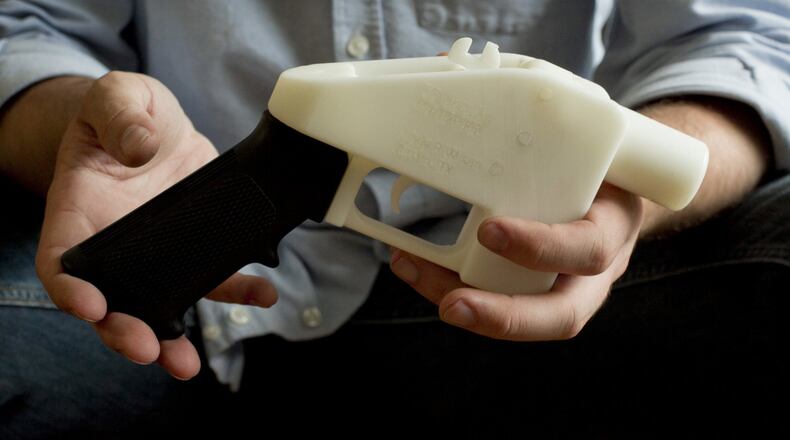 Cody Wilson holds what he calls a Liberator pistol that was completely made on a 3-D-printer at his home in Austin, Texas. Eight states filed suit Monday, July 30, 2018, against the Trump administration over its decision to allow a Texas company to publish downloadable blueprints for a 3D-printed gun, contending the hard-to-trace plastic weapons are a boon to terrorists and criminals and threaten public safety. (Jay Janner/Austin American-Statesman via AP, File)