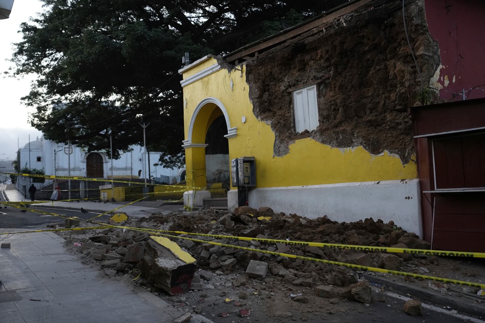 A police tape surrounds a damaged building in Palin, Guatemala, Wednesday, July 9, 2025, after a series of earthquakes with magnitudes ranging from 3.0 to 5.6, according to authorities. (AP Photo/Moises Castillo)