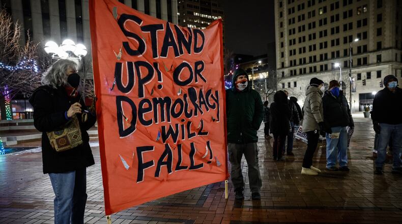 Around 75 people attended a candlelight vigil and rally to remember the January 6 attack on the US capitol at Courthouse Square Thursday night. Jim Noelker/Staff
