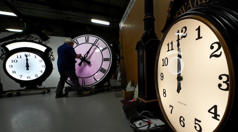 Clockmaker Scott Gow adjusts the hands of a clock at the Electric Time Company, Wednesday, Oct. 30, 2024, in Medfield, Mass. (AP Photo/Charles Krupa)