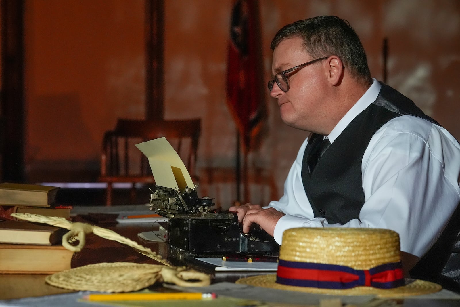 Anthony Smith who plays the roles of Walter White and Sue Hicks in the play "Destiny in Dayton" sits with a typewriter during a rehearsal, July 8, 2025, in Dayton, Tenn. (AP Photo/Mike Stewart)