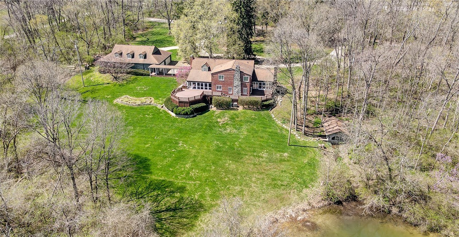 The property includes an original spring house that is over the spring that feeds the pond. The detached garage has a finished upper floor with an additional bathroom.