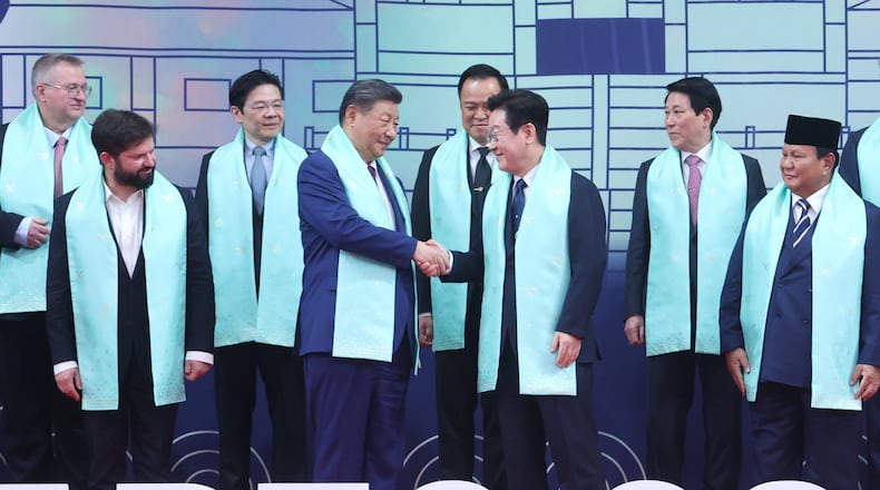 Chinese President Xi Jinping, center left, and South Korean President Lee Jae Myung, center right, shake hands after a group photo at the Asia-Pacific Economic Cooperation (APEC) Economic Leaders' Meeting in Gyeongju, South Korea, Saturday, Nov. 1, 2025. (Yonhap via AP)