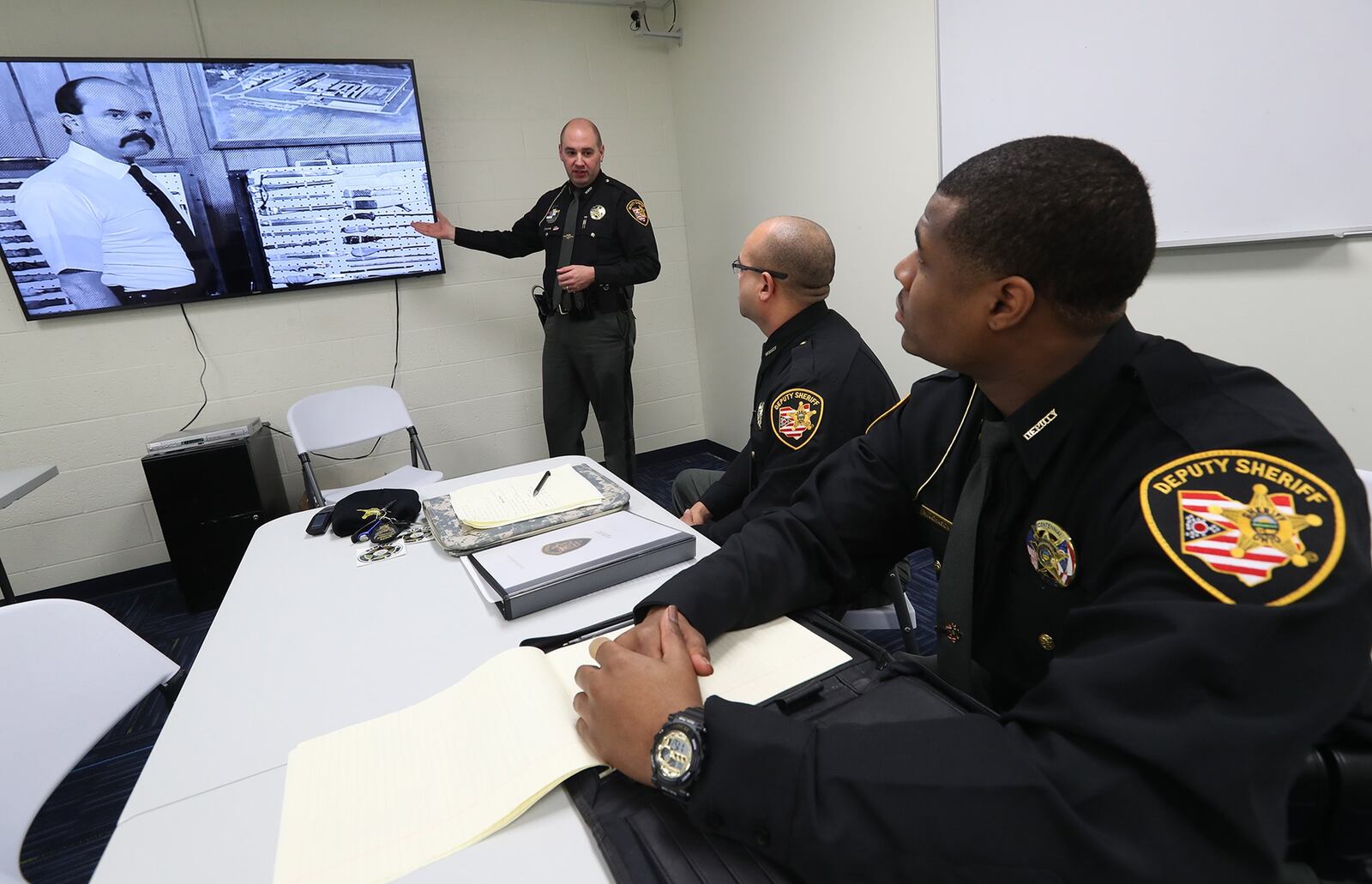Clark County Sheriff’s Deputy John Loney talks to new deputies Jordan Bean and Marcus Johnson as they watch a training video in the Clark County Jail Tuesday. Bill Lackey/Staff
