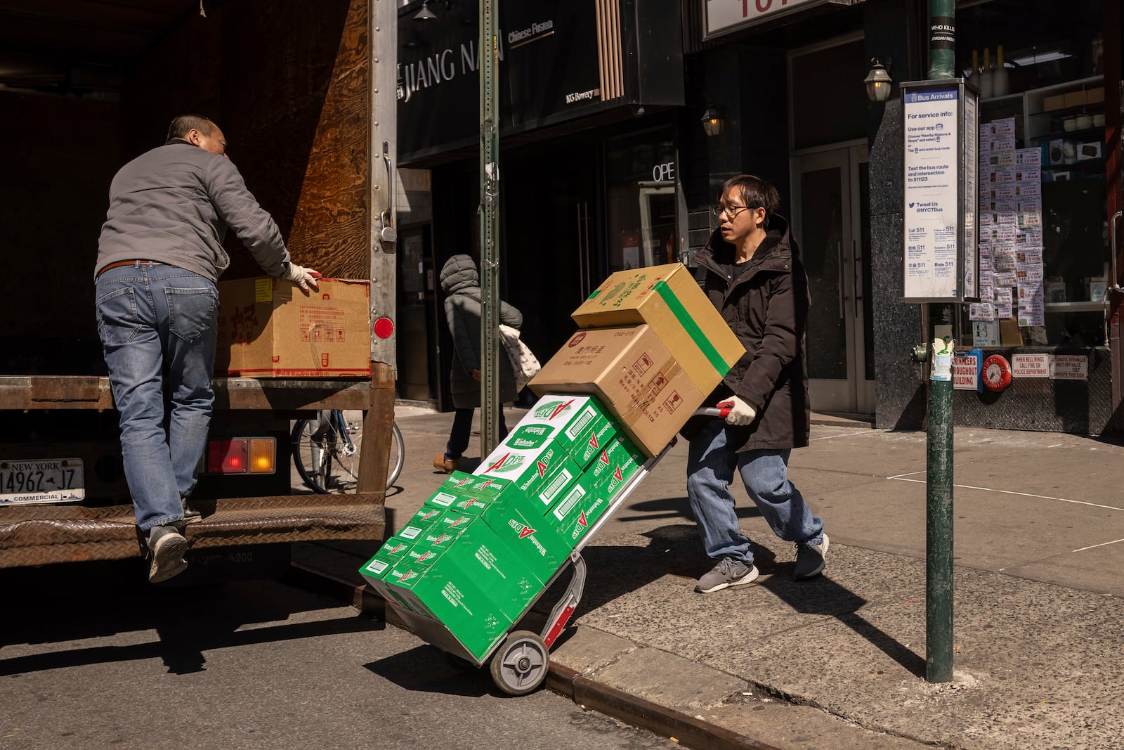 FILE - Delivery workers carry boxes outside a grocery store in the Chinatown neighborhood, Wednesday, April 9, 2025, in New York. (AP Photo/Yuki Iwamura, File)