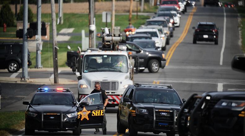 Clark County sheriff's deputies block the road and an Ohio Edison truck is shown as traffic backs up in Moorefield Township on Monday. A man climbed a power substation, and electricity was our for nearly 2,500 customers in the Northridge area before the man could be talked into coming down. MARSHALL GORBY/STAFF