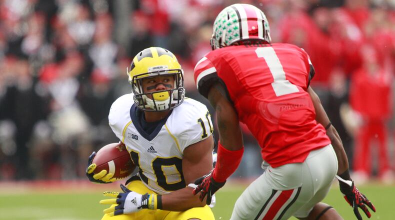 Jeremy Gallon (10) of Michigan is pursued by Bradley Roby (1) of Ohio State during Saturday's game at Ohio Stadium in Columbus. The Ohio State University Buckeyes beat Michigan 26-21 to finish an undefeated 12-0 season at home in Ohio Stadium on Saturday, Nov. 24, 2012. Photo by Barbara J. Perenic/Cox Media Group