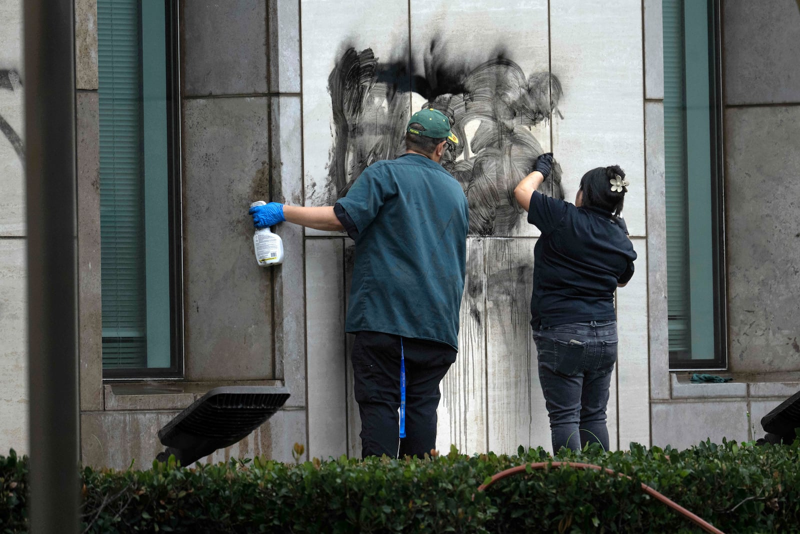 Workers remove graffiti from the Ronald Reagan Federal Building and Courthouse in Santa Ana, Calif., Tuesday, June 10, 2025, after Monday's protests against President Trump's ICE raids resulted in violence. (Mindy Schauer/The Orange County Register via AP)