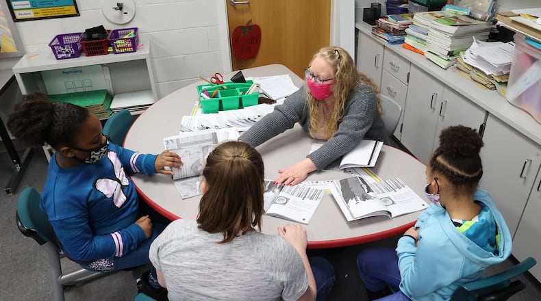 Beckitt Bostick, a second grade teacher at Perrin Woods Elementary, works with a small group of students Wednesday. BILL LACKEY/STAFF