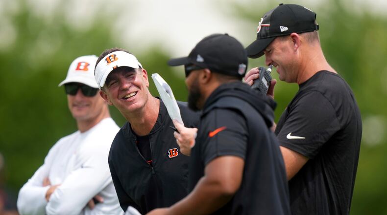 Cincinnati Bengals defensive coordinator Lou Anarumo, second from left, laughs with secondary/cornerbacks coach Charles Burks, second from right, and head coach Zac Taylor, right, during the team's NFL football training camp practice, Friday, July 28, 2023, in Cincinnati. (Kareem Elgazzar/The Cincinnati Enquirer via AP)