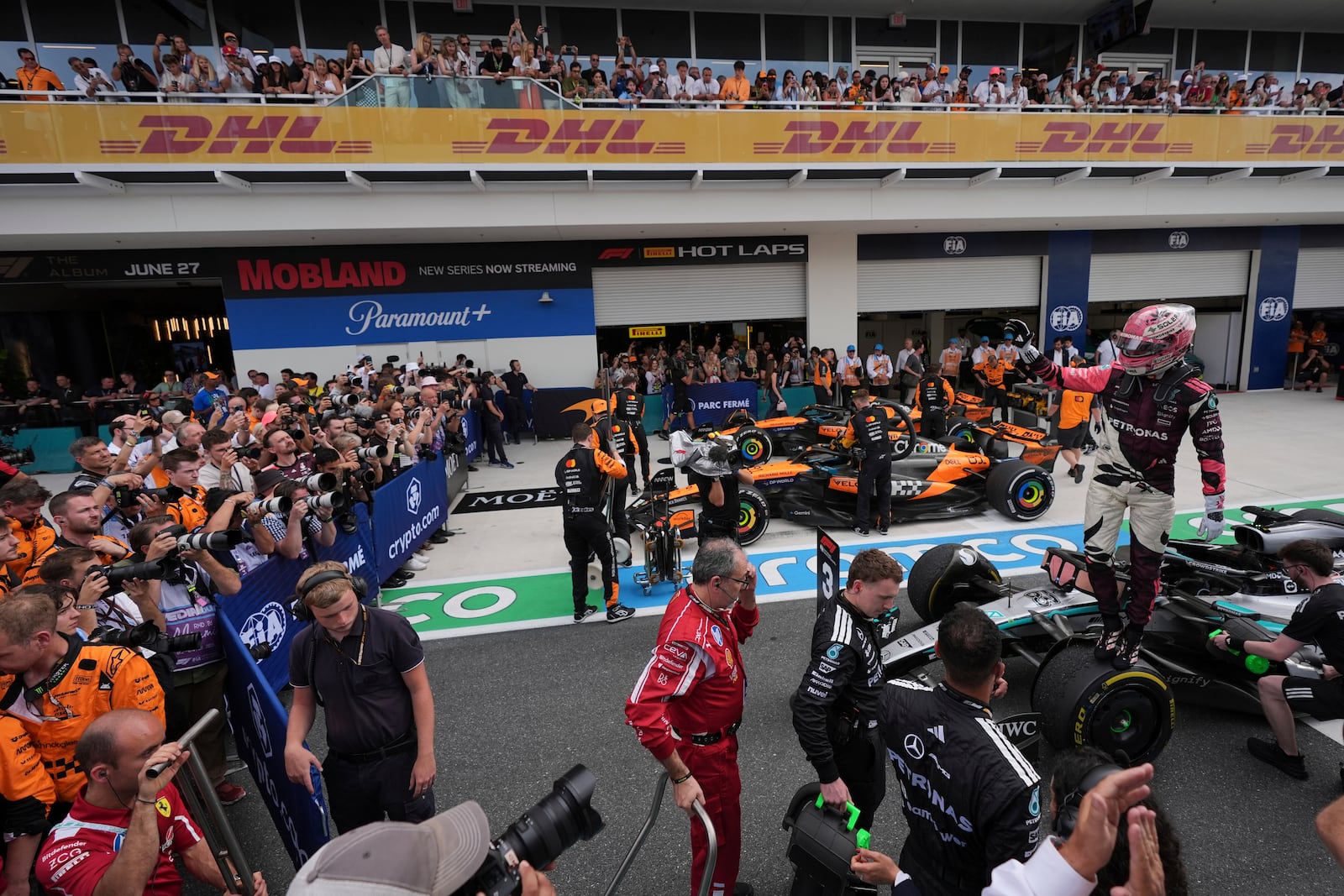 Mercedes driver George Russell of Britain, right, stands on top of his car after a third place finish in the Formula One Miami Grand Prix auto race Sunday, May 4, 2025, in Miami Gardens. Fla. (AP Photo/Rebecca Blackwell)