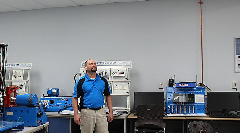 Clark State Community College employee Dan Ayers shows some of the LED lights that are installed in Shull Hall on Campus. JEFF GUERINI/STAFF
