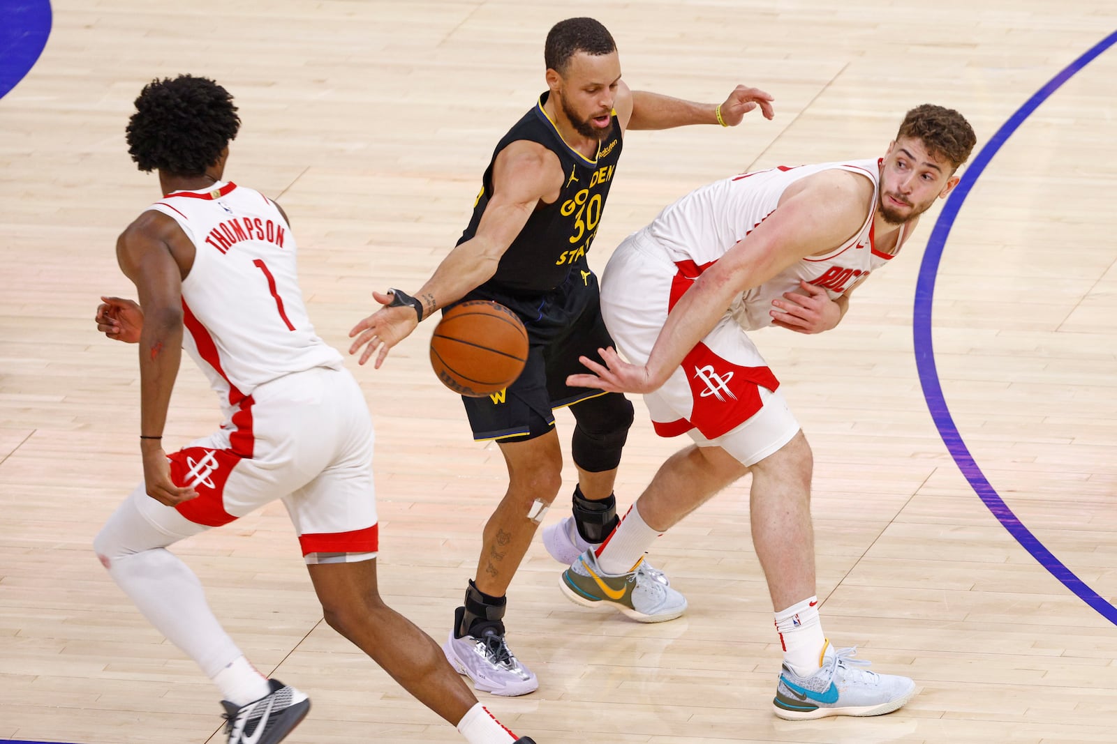 Houston Rockets center Alperen Sengun (28) passes to Rockets forward Amen Thompson (1) while guarded by Golden State Warriors guard Stephen Curry (30) in the fourth quarter of Game 6 of an NBA basketball first-round playoff series Friday, May 2, 2025, in San Francisco. (Santiago Mejia/San Francisco Chronicle via AP)