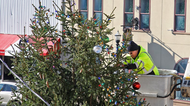 Greg Slattery, from the City of New Carlisle, uses a bucket truck to decorate the top of the city's Christmas tree Wednesday, Nov. 29, 2023. The lights on the tree will officially be turned on Friday night during a ceremony in downtown New Carlisle followed Saturday morning by the annual Christmas Parade. BILL LACKEY/STAFF
