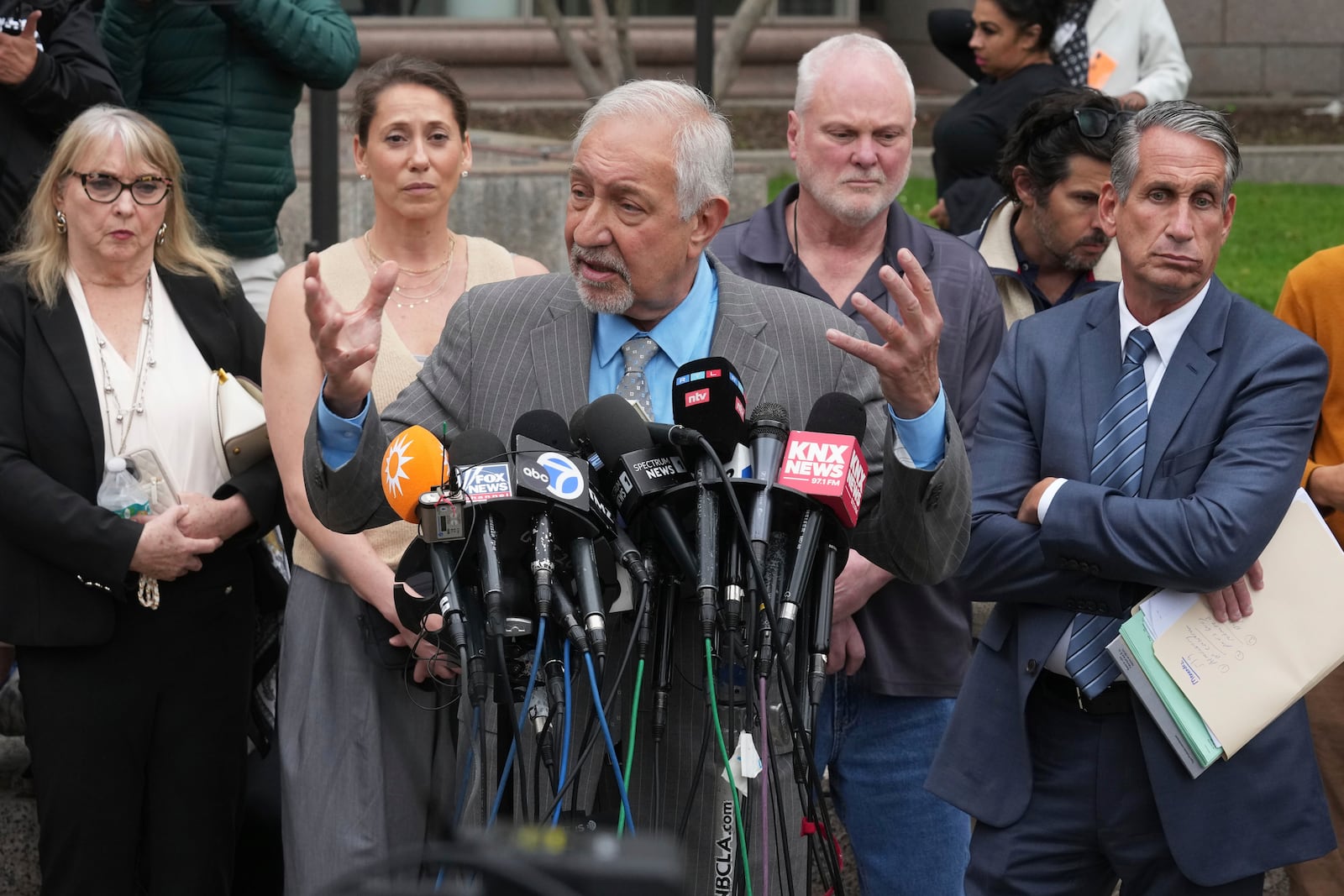 Attorney Mark Geragos, center, representing Erik and Lyle Menendez, who were sentenced in 1996 to life in prison without the possibility of parole for fatally shooting their parents, speaks to the media outside of court after a resentencing hearing in their case, Thursday, April 17, 2025, in Los Angeles. (AP Photo/Damian Dovarganes)