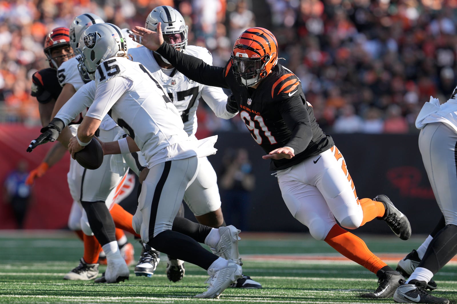 Cincinnati Bengals defensive end Trey Hendrickson (91) applies pressure to Las Vegas Raiders quarterback Gardner Minshew II (15) during the second half of an NFL football game in Cincinnati, Sunday, Nov. 3, 2024. (AP Photo/Jeff Dean)