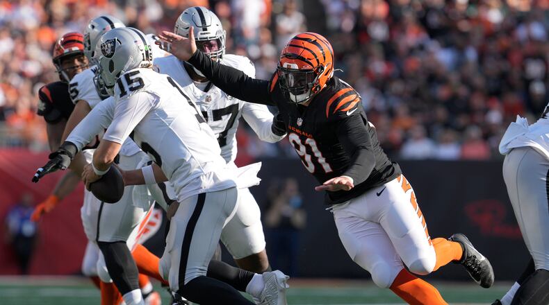 Cincinnati Bengals defensive end Trey Hendrickson (91) applies pressure to Las Vegas Raiders quarterback Gardner Minshew II (15) during the second half of an NFL football game in Cincinnati, Sunday, Nov. 3, 2024. (AP Photo/Jeff Dean)