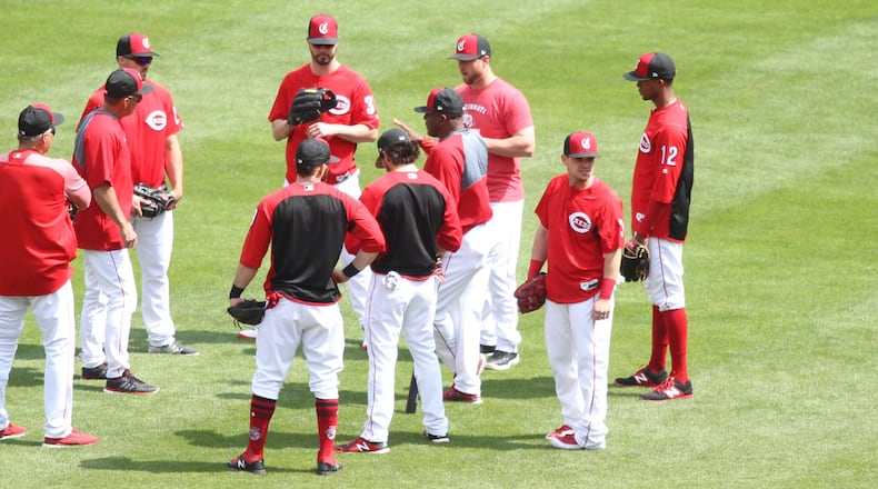 Reds players huddle around Billy Hatcher before batting practice on Monday, May 7, 2018, at Great American Ball Park in Cincinnati. David Jablonski/Staff