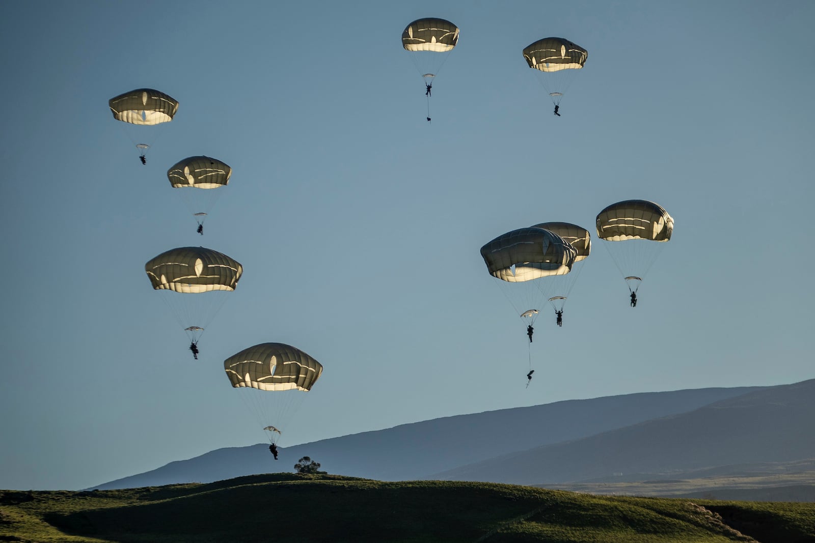 In this photo released by the U.S. Army, soldiers jump from the C-17 Globemaster III during Joint Pacific Multinational Readiness Center (JPMRC) 25-01 at Pohakuloa Training Area, Hawaii, Oct. 7, 2024. (Sgt. 1st Class Ryele Bertoch, U.S. Army via AP))