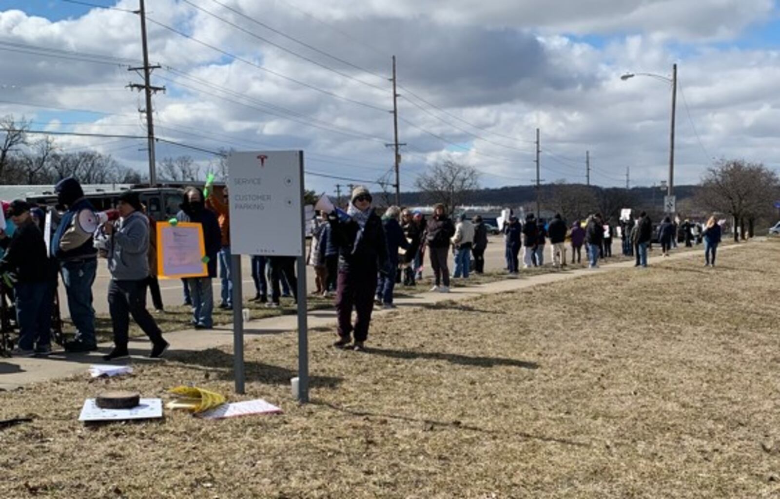 Hundreds of people lined West Dorothy Lane in Moraine on Saturday, March 1, 2025 to protest near a Tesla Service Center. The protest was aimed at Elon Musk, the world's richest man, and his actions with the Trump administration and the Department of Government Efficiency. BROOKE SPURLOCK/STAFF
