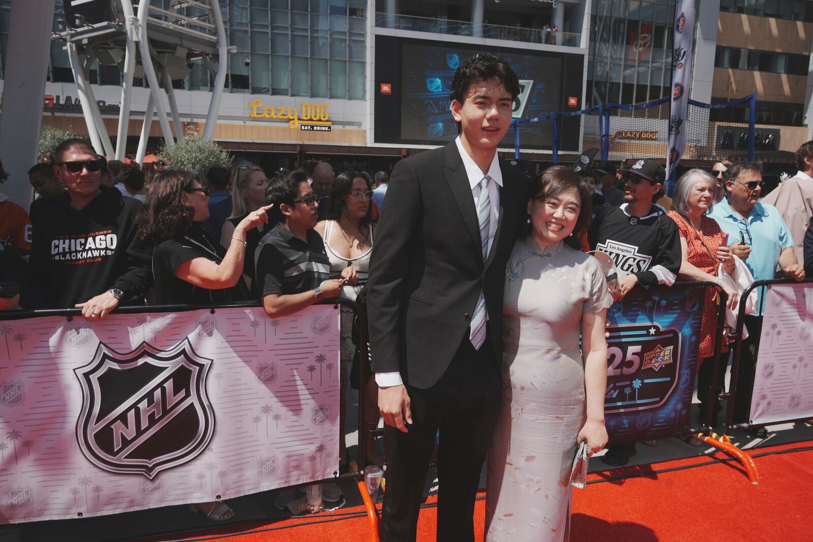 Simon Wang poses with his mother on the red carpet before the NHL hockey draft Friday, June 27, 2025, in Los Angeles. (AP Photo/Damian Dovarganes)