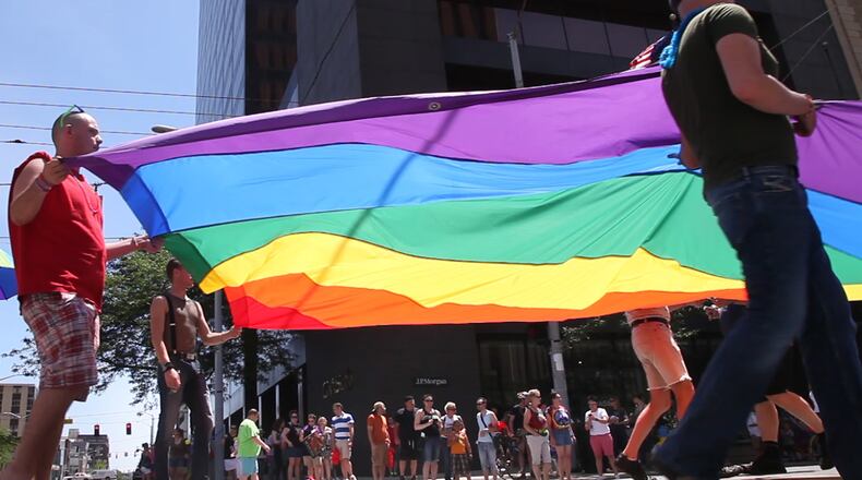 Attendees at a previous Dayton gay pride celebration carry a rainbow flag. FILE PHOTO