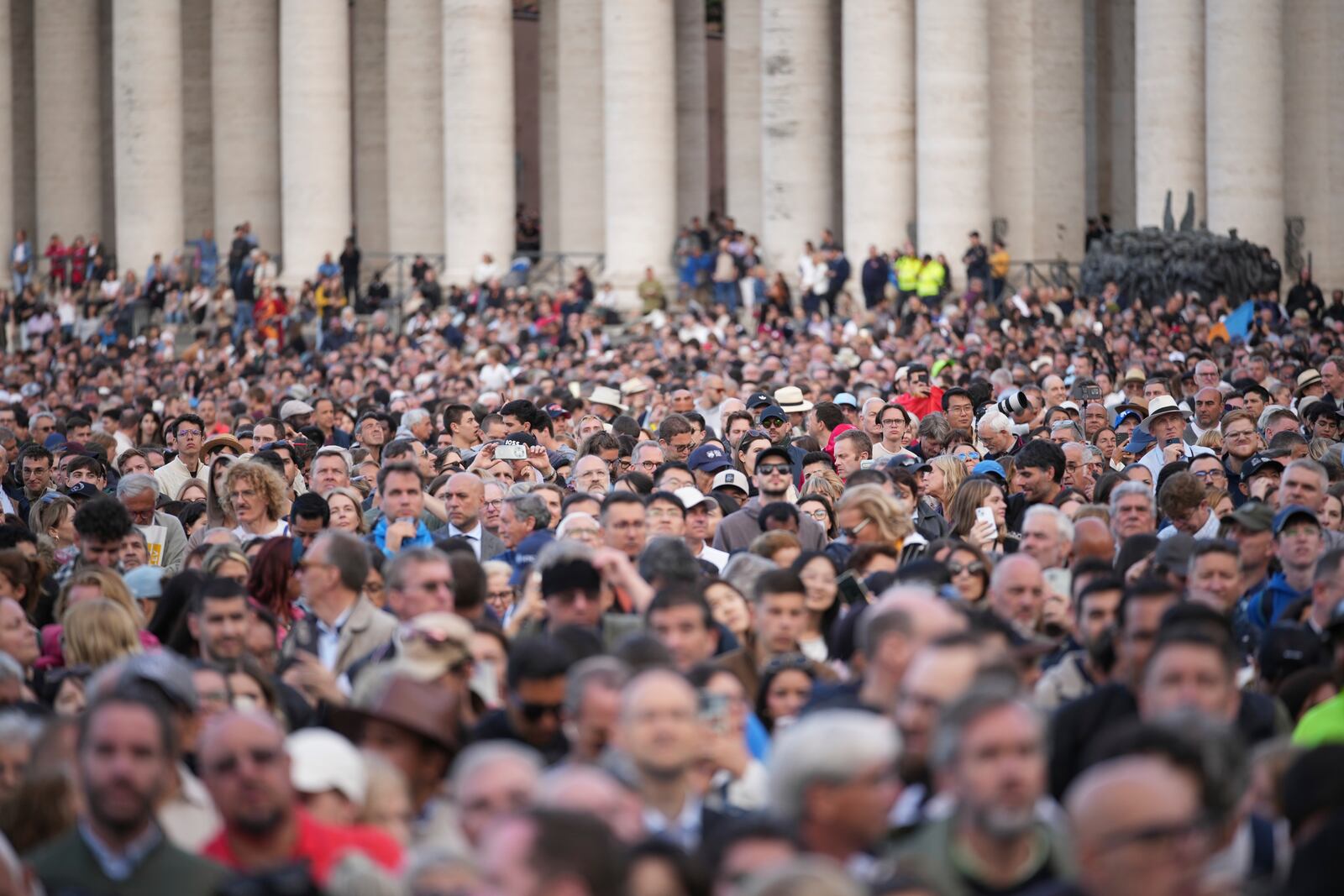 People gather in St Peter's Square as they wait to see the smoke billow from the chimney of the Sistine Chapel in St Peter's Square during the cardinals' conclave to elect a new pope, at the Vatican, Wednesday, May 7, 2025. (AP Photo/Andrew Medichini)