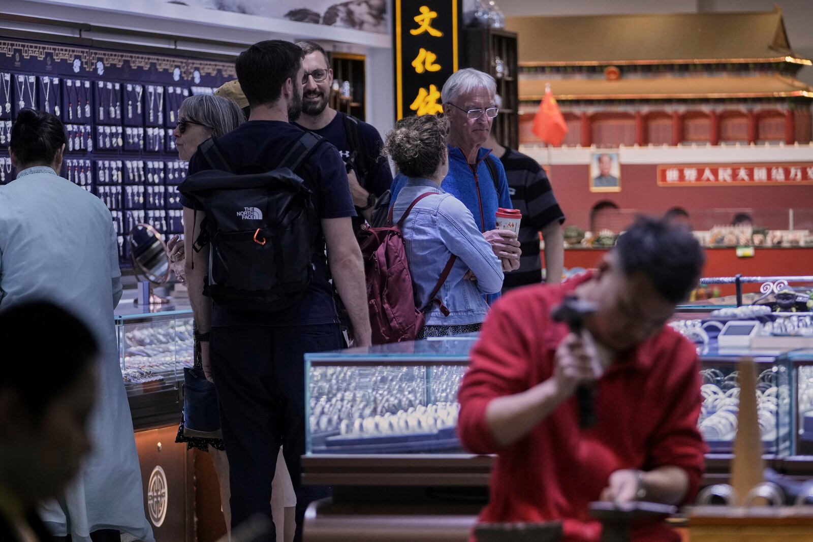 Tourists shop at a fashion jewelry store as they tour Qianmen pedestrian shopping street in Beijing, Sunday, April 27, 2025. (AP Photo/Andy Wong)