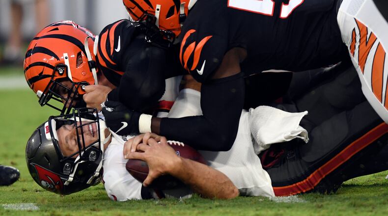Cincinnati Bengals defensive end Sam Hubbard (94) and defensive end Joseph Ossai (58) team up to sack Tampa Bay Buccaneers quarterback Tom Brady (12) during the first half of an NFL preseason football game Saturday, Aug. 14, 2021, in Tampa, Fla. (AP Photo/Jason Behnken)