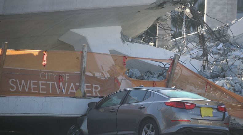 A car is seen stuck under the rubble as law enforcement and members of the National Transportation Safety Board investigate the scene where a pedestrian bridge collapsed a few days after it was built over southwest 8th street allowing people to bypass the busy street to reach Florida International University on March 16, 2018 in Miami, Florida. Reports indicate that there are six fatalities as a result of the collapse. (Photo by Joe Raedle/Getty Images)