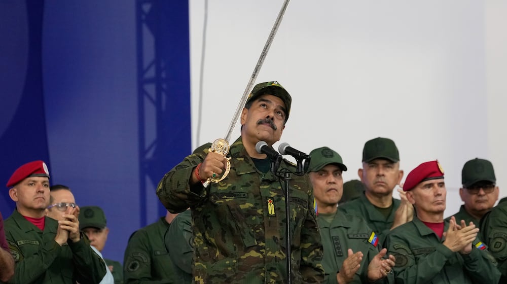 Venezuelan President Nicolas Maduro brandishes a sword said to have belonged to independence hero Simon Bolivar during a civic-military event at the military academy in Caracas, Venezuela, Tuesday, Nov. 25, 2025. (AP Photo/Ariana Cubillos)