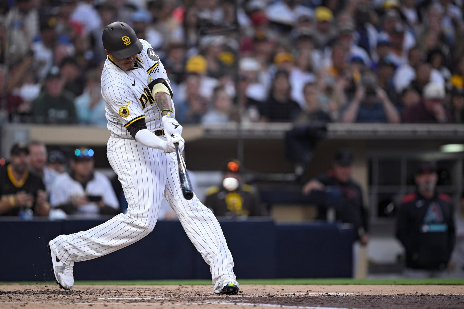 San Diego Padres' Manny Machado hits a single, his 2000th career hit, during the fourth inning of a baseball game against the Arizona Diamondbacks Monday, July 7, 2025, in San Diego. (AP Photo/Orlando Ramirez)