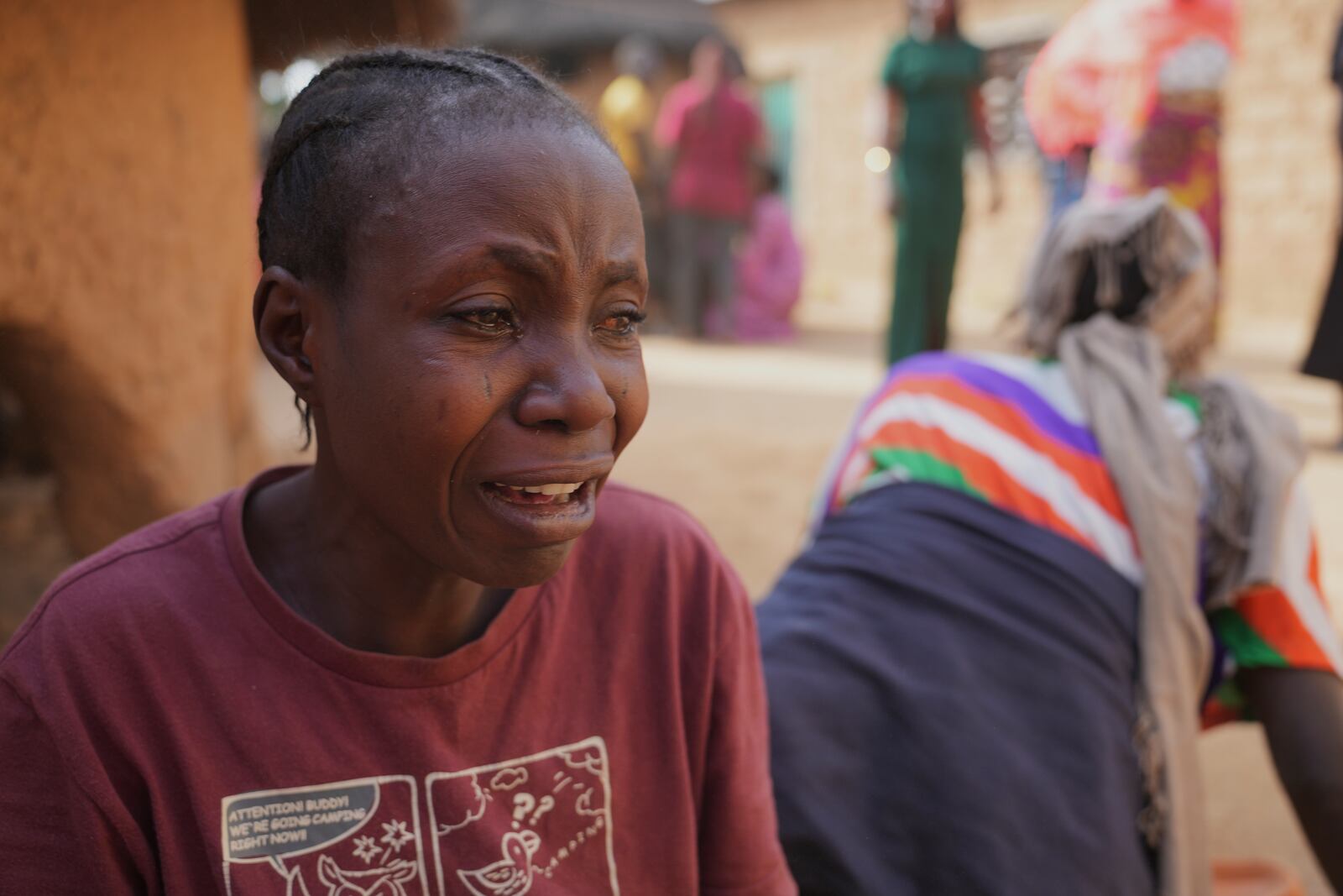 A woman mourns the death of a family member following an attack by gunmen in the Zike farming community in north-central Nigeria, Tuesday, April 15, 2025. (AP Photo/Samson Omale)