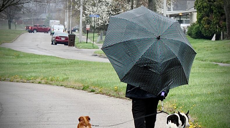 You can expect a lot of dog gone rain Wednesday April 13, 2022. Keep your umbrella handy like this lady in Trotwood walking her dogs on Brumbaugh Boulevard. MARSHALL GORBY \STAFF