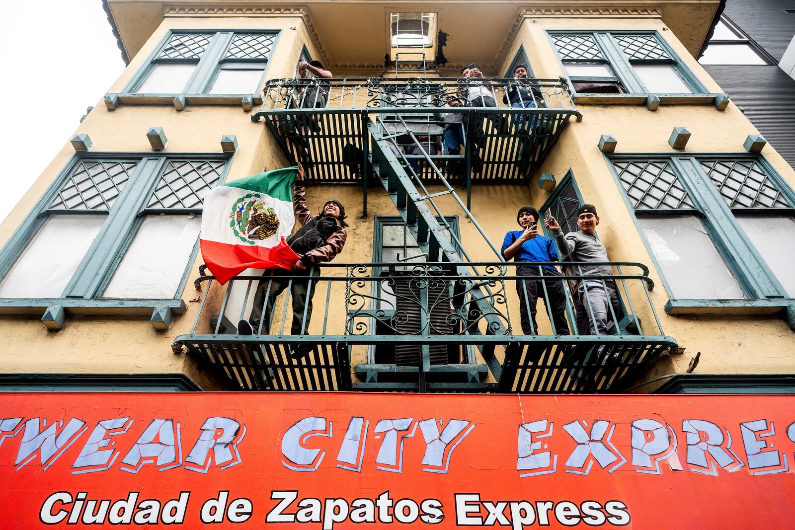 A man waves a Mexican flag as protesters against U.S. Immigration & Customs Enforcement raids march through San Francisco's Mission district on Monday, June 9, 2025. (AP Photo/Noah Berger)