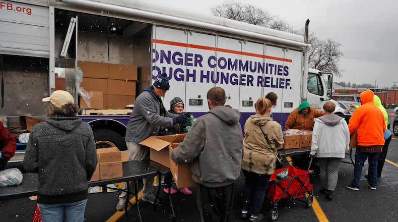 Volunteers pass out food at Second Harvest Food Bank's Mobile Pantry Wednesday, Nov. 16, 2022 in the parking lot of the First United Church of Christ in Springfield. BILL LACKEY/STAFF