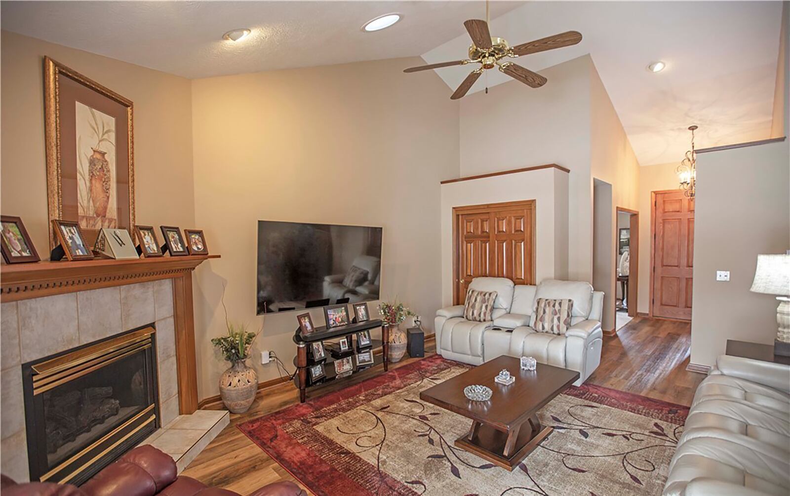 The living/great room is central to the home and has a vaulted ceiling, hardwood flooring and a corner gas fireplace.