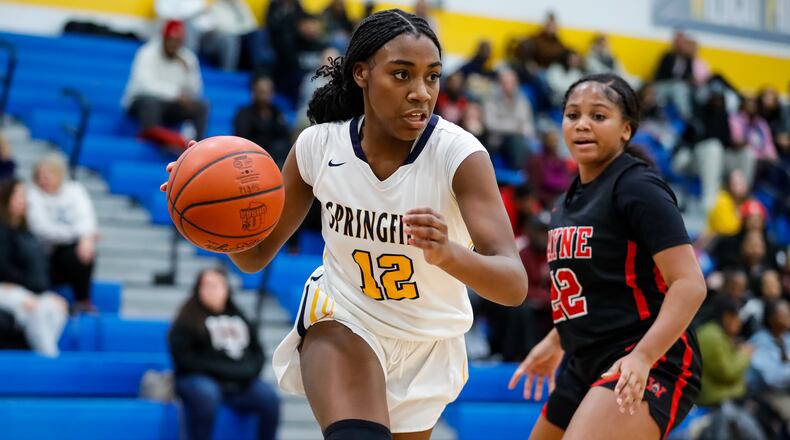 Springfield High School sophomore Day'veonna Boynton drives past Wayne's Tionne McMillon during their game on Wednesday night in Springfield. The Wildcats won 56-37. Michael Cooper/CONTRIBUTED