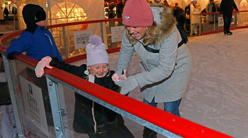 Lyndsay Stewart tries to keep her daughter, Emma, from falling Friday, Nov. 29, 2024 as they try out the outdoor ice skating rink on the Springfield City Hall Plaza during the Holiday in the City Grand Illumination. BILL LACKEY/STAFF