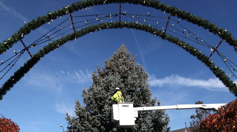 Members of the City of Springfield Service Department wrap the city's holiday tree in thousands of light on the Springfield Esplanade earlier this month in preparation of Holiday in the City. BILL LACKEY/STAFF