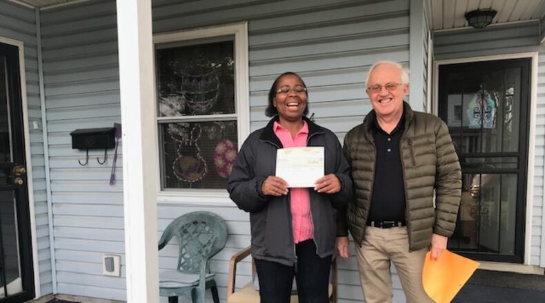 Springfield’s Angela Kelly, left, stands with Clark County Fuller Center Board President Vince Chase and holds her free and clear deed for her home that she purchased through the local nonprofit’s zero-interest low-income home ownership program and paid off last year. CONTRIBUTED